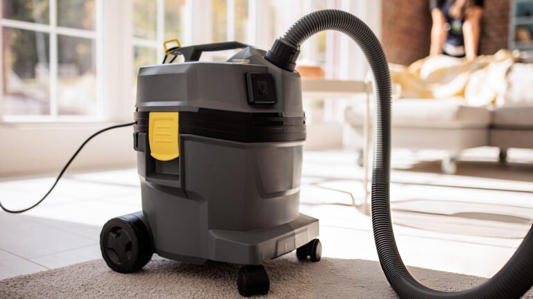 Wet dry vacuum cleaner removing both liquid spills and solid debris from a home garage floor